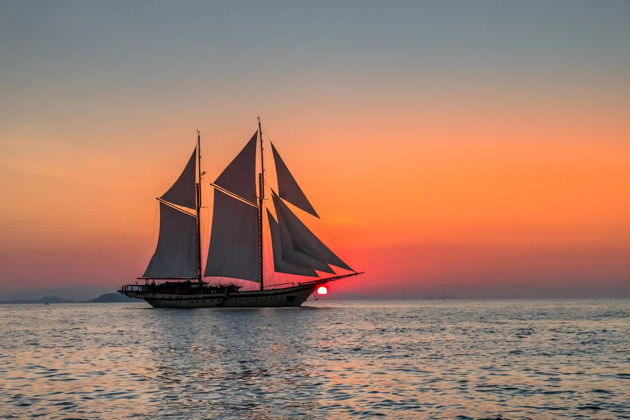 Phinisi silhouetted at sunset in Komodo